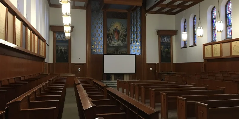 Church at the facility with stained-glass windows and whiteboard in front.