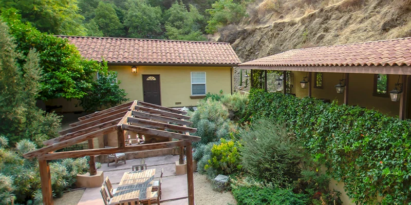 Outdoor seating area with chairs and a pergola.