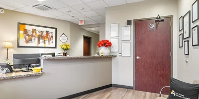 Reception area with granite counter, flowers, and framed documents