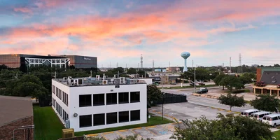 Side view of white rehab facility under a colorful sunset sky