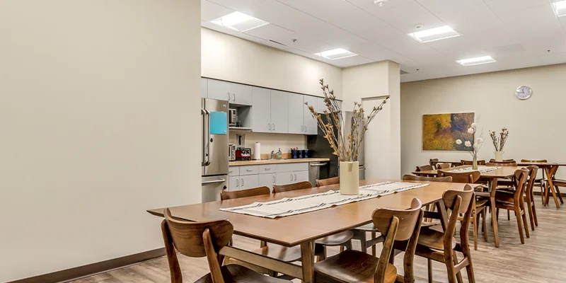 Dining area with tables and chairs and a kitchenette.