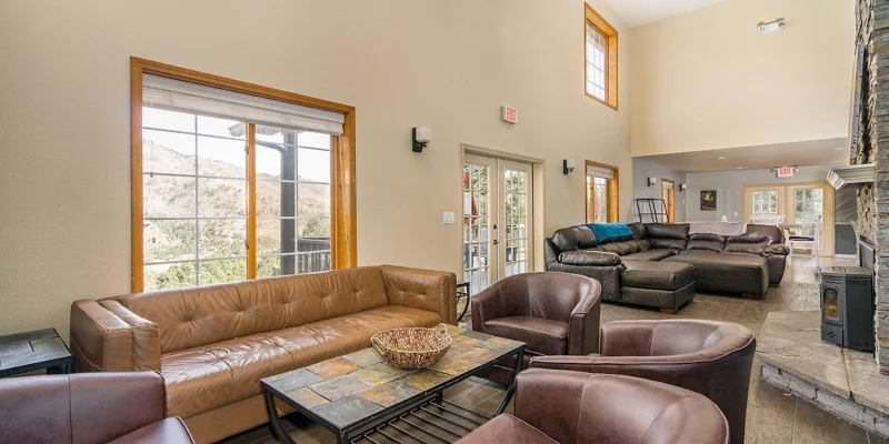 Living room with  leather seating, and a stone fireplace.