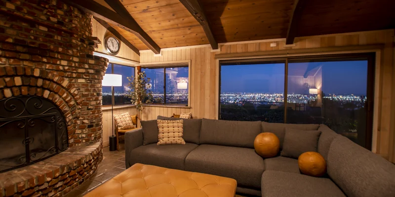 Cozy lounge with a brick fireplace, city lights visible at night