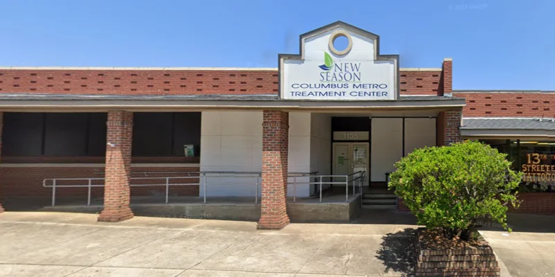 Clinic exterior with large sign and parking area in front.