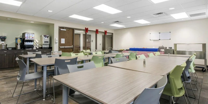 Rehab dining area with modern tables, chairs, and a food service counter.