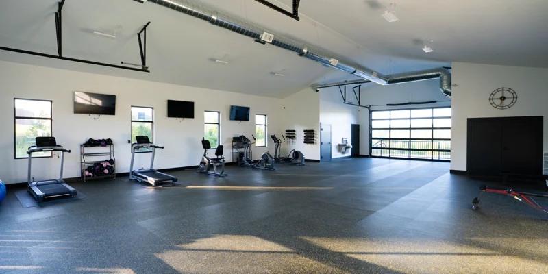 Spacious gym with treadmills, bikes, and large windows