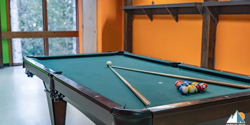 A pool table with cues and billiard balls in a recreation room