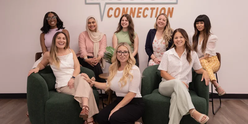 A group of ladies on green couches and Mission Connection.