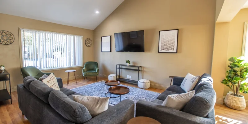 A modern lounge area with a large TV and stylish seating.