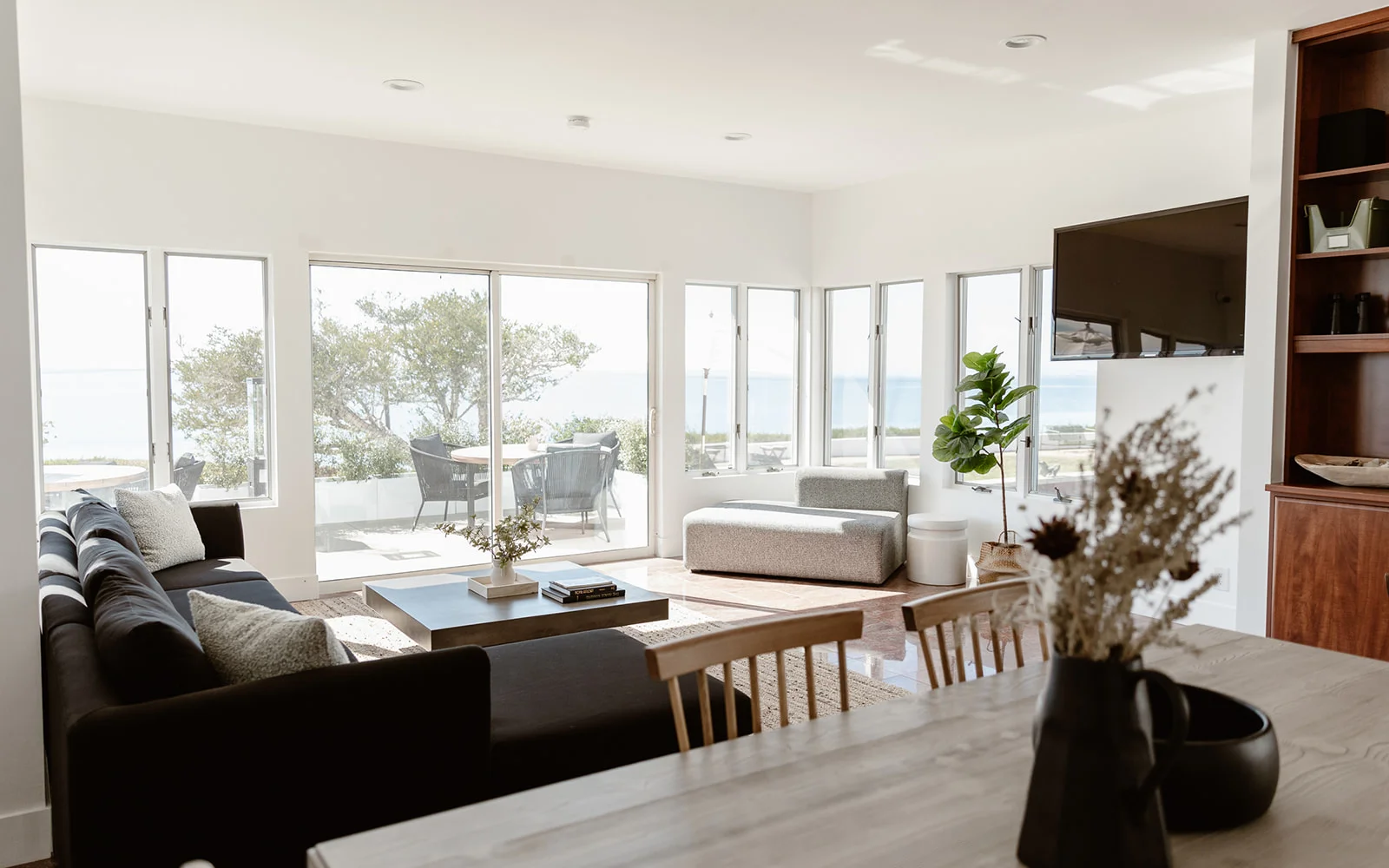 Bright living space with ocean views, modern furniture, and natural decor.