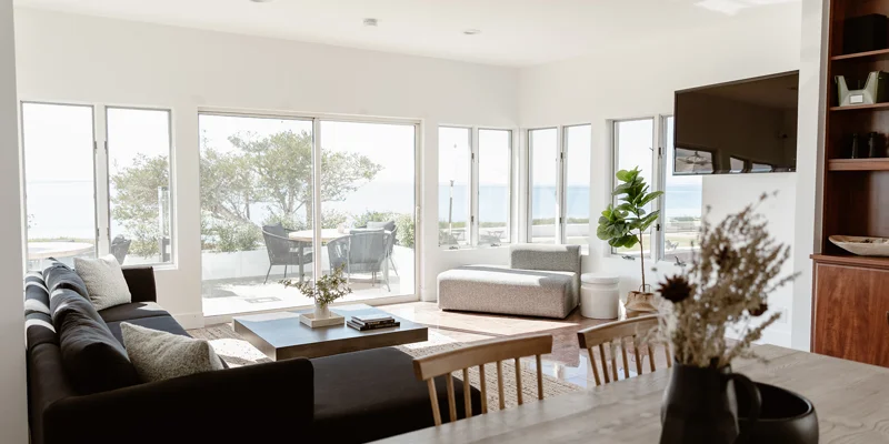 Bright living space with ocean views, modern furniture, and natural decor.