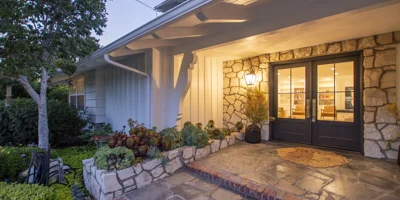A warmly lit facility entrance with stone walls and double doors.
