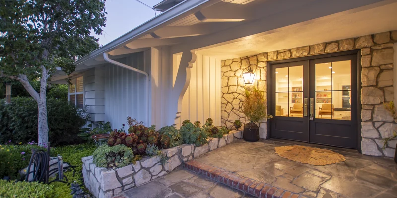 A warmly lit facility entrance with stone walls and double doors.