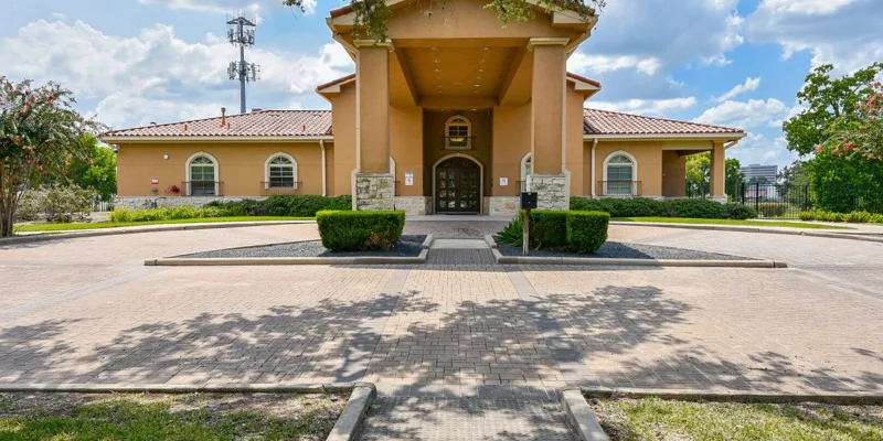 Rehab facility entrance with red-tiled roof and greenery.