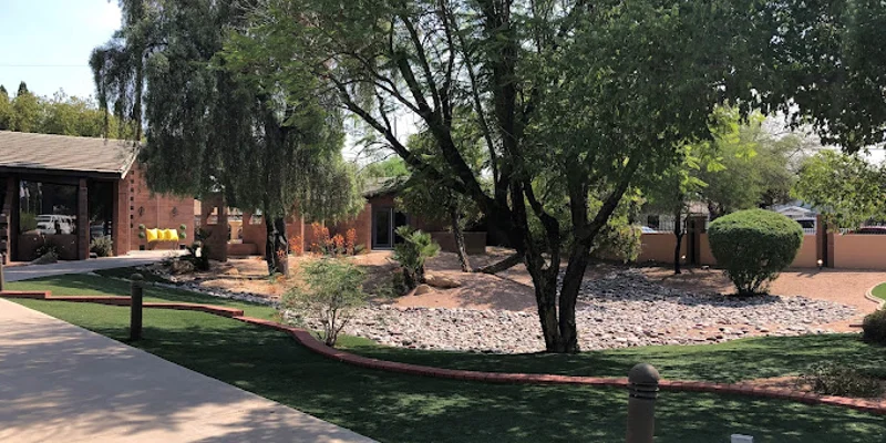 Contemporary facility exterior with trees and lanscaped walkway.