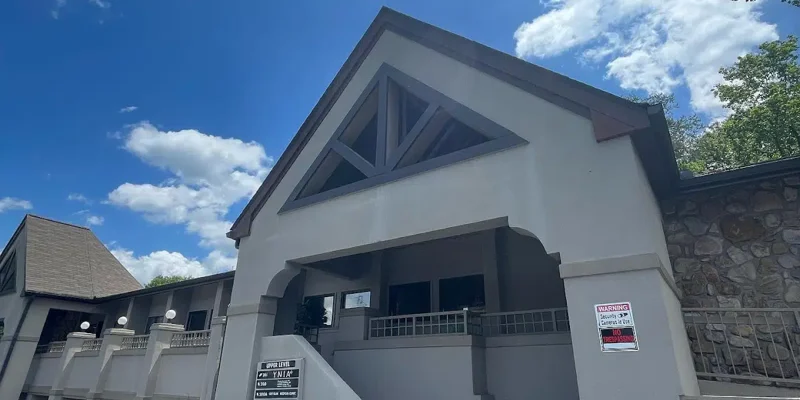Two-story building with stairs and parking area