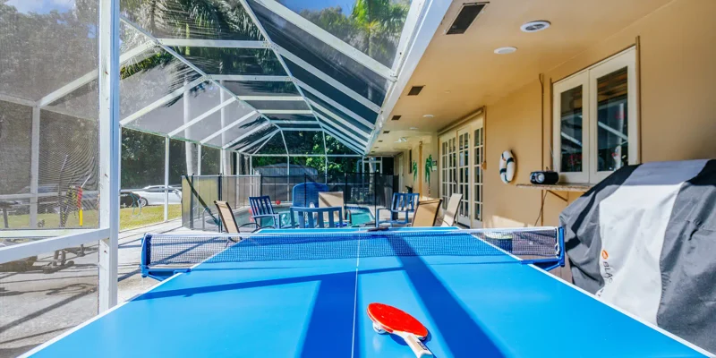Outdoor ping pong table beside pool seating area