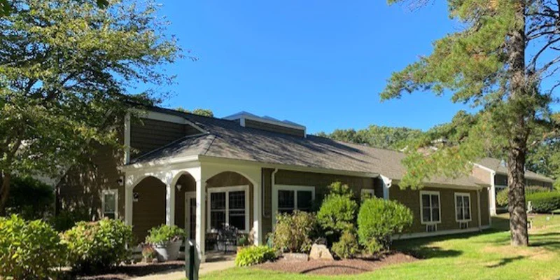 The exterior of a rehab center surrounded by greenery and landscaping.