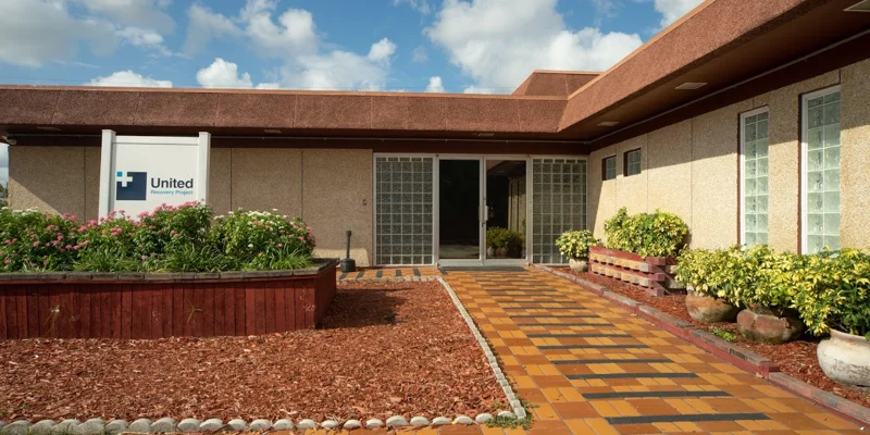 Facility exterior with signage, brick walkway and landscaping to entrance.
