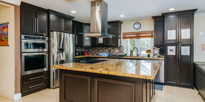 Modern kitchen with granite island and dark cabinets