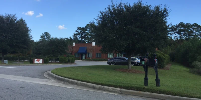 Facility driveway to entrance with parking.