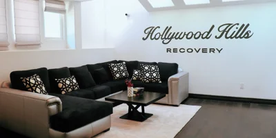 Living room with sectional couch and Hollywood Hills Recovery sign