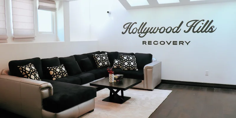Living room with sectional couch and Hollywood Hills Recovery sign