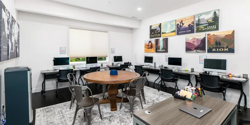 Computer room with chairs paired to desktops.