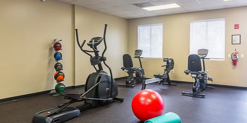 Fitness room with exercise bikes, elliptical, and workout equipment.