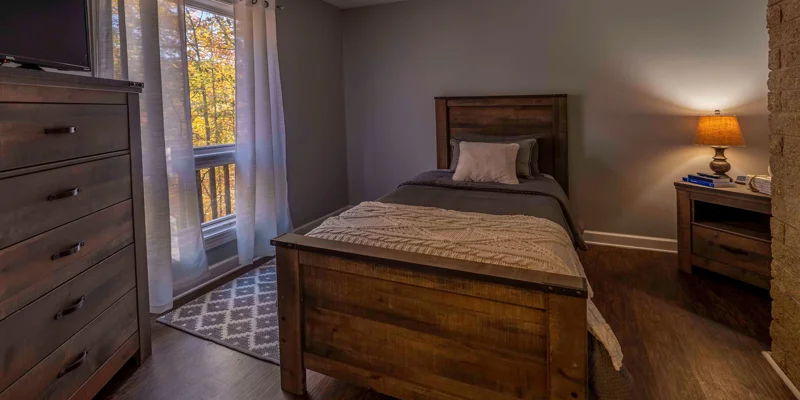A cozy bedroom with a wooden bed frame and warm lighting