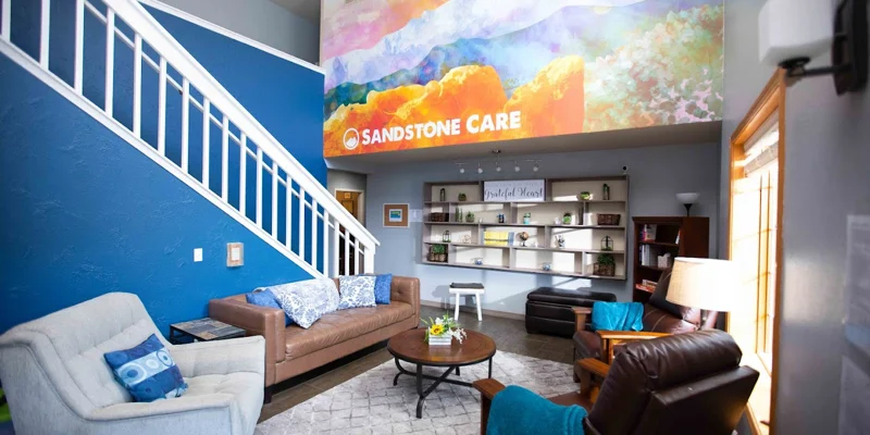 Living space with signage, wall art, seating, and a bookshelf.
