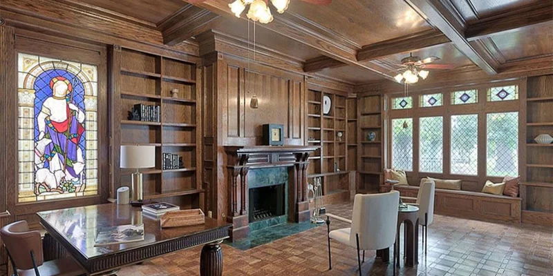Study with chairs, a fireplace, and bookshelves.