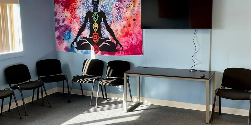 Group therapy room with chairs arranged in a circle and a TV.