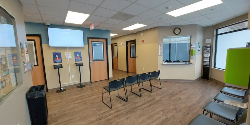 Waiting area with reception window and seating.