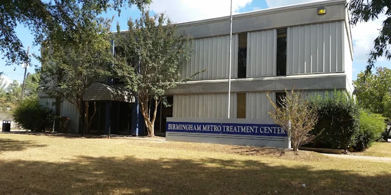 Exterior of Birmingham Metro Treatment Center with trees and signage.