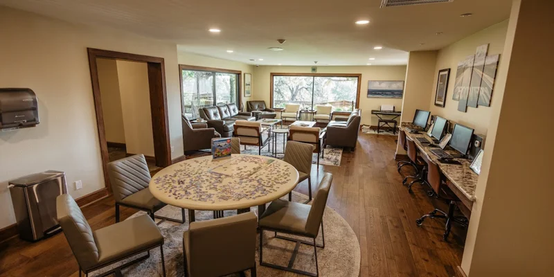 Lounge area with seating, computers, and large windows
