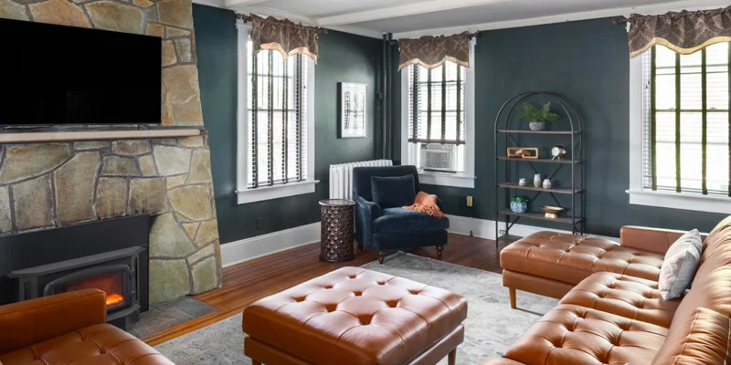 Lounge with a stone fireplace, seating, and windows.