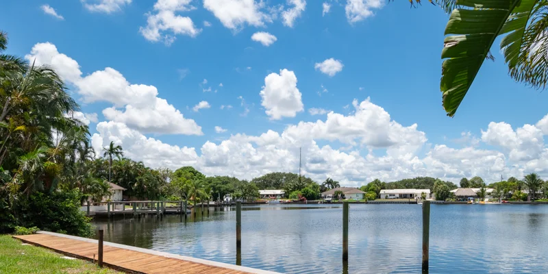 View of lakefront and wooden dock under blue sky