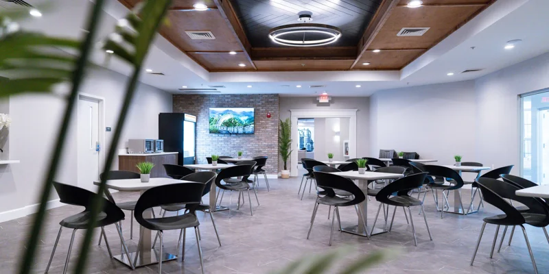 Cafeteria area with shared tables and seating, with snack bar.