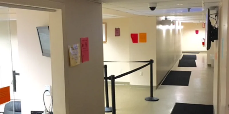 Hallway leading past a reception window.