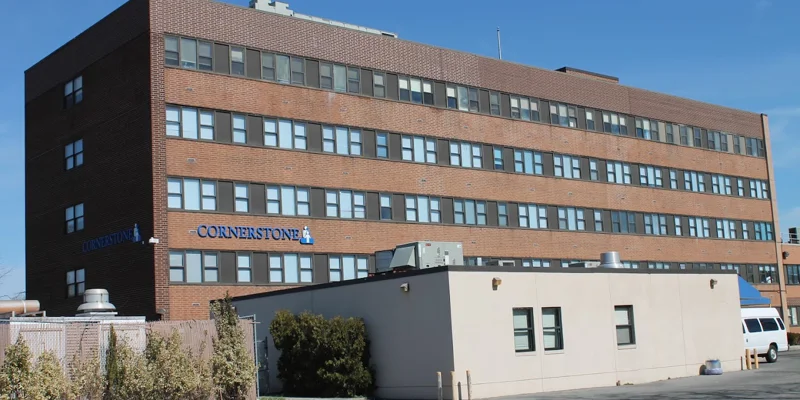 Back street view of Cornerstone Of Medical Arts Center building with parking.