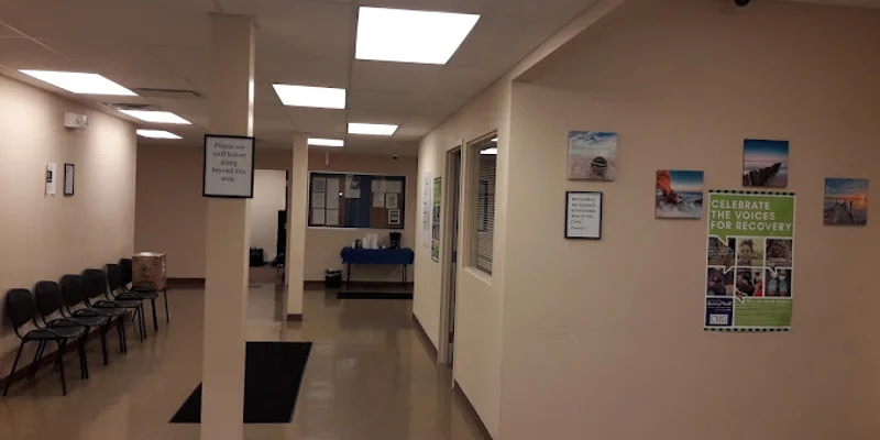 nterior waiting room with row of chairs against a wall.