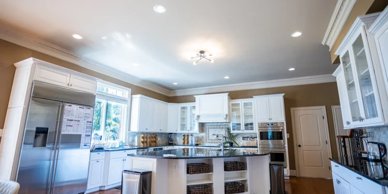 A modern kitchen with white cabinetry and a large center island