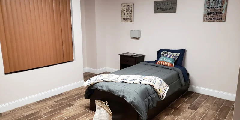 Cozy single bedroom with motivational wall art.