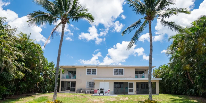Back exterior of two-story building with palm trees