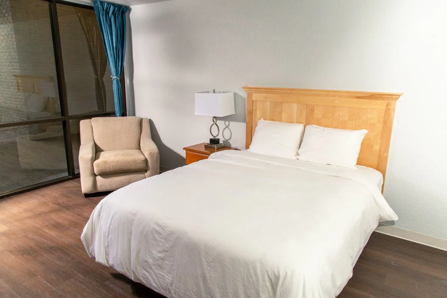 Private bedroom with a bed and and armchair.