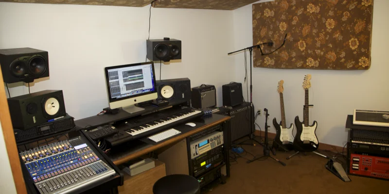 A modern music studio with guitars, speakers, and recording equipment