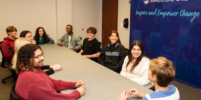 People seated around a table in a group meeting.