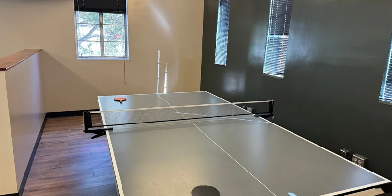 Recreational area featuring a ping pong table and dark green walls.