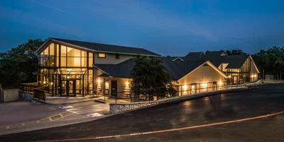 Modern rehab facility with glass walls, lit at night